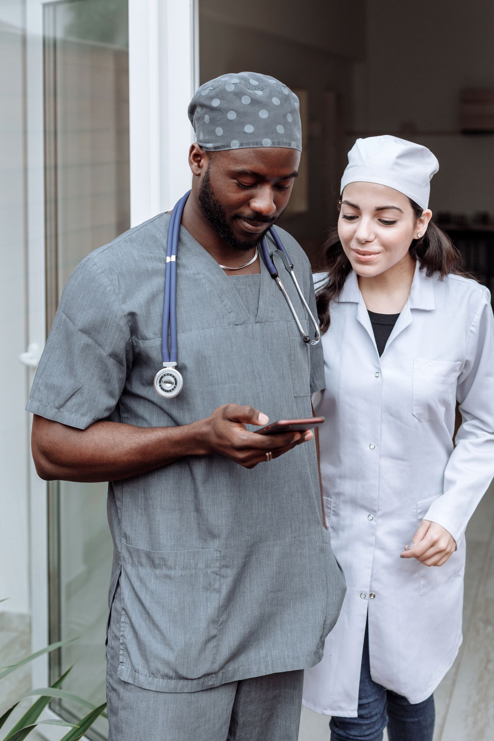 Two healthcare professionals reviewing clinical information together on a smartphone